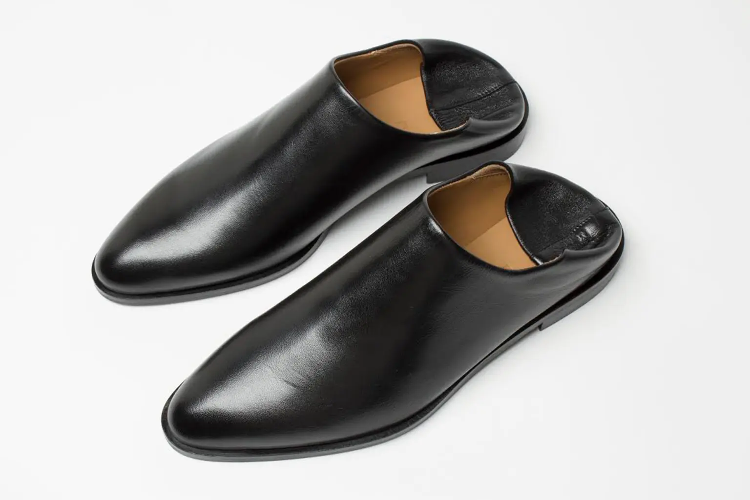 Brat bliźniak Kaczyńskiego Para czarnych skórzanych męskich butów, z przydeptanymi piętami.